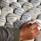 Un hombre escribe en un memorial a las víctimas en Perú. / C. B. (AFP)